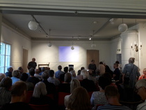 Puheenjohtaja Pekka Ahokkaan tervehdys runsaalle osanottajajoukolle. Eila Metsäpelto tapahtuman juontajana.